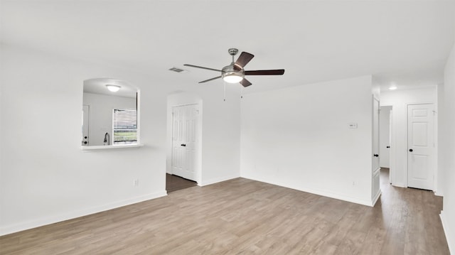 13124 Winecup Mallow Trl, Elgin, TX 78621 - unfurnished room featuring ceiling fan, wood finished floors, and arched walkways