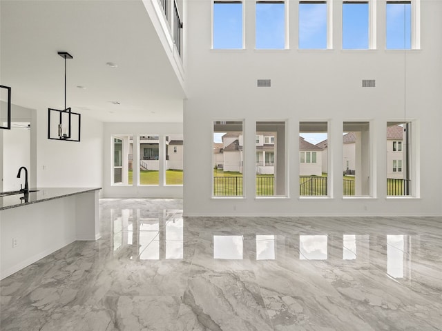 2308 Mondello Path, Leander, TX 78641 - unfurnished living room featuring a towering ceiling and marble tiled flooring