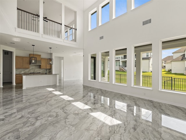 2308 Mondello Path, Leander, TX 78641 - unfurnished living room featuring light marble finish floors and a towering ceiling