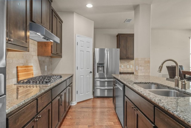 204 Archipelago Trl, Austin, TX 78717 - kitchen with appliances with stainless steel finishes, under cabinet range hood, light stone countertops, and recessed lighting