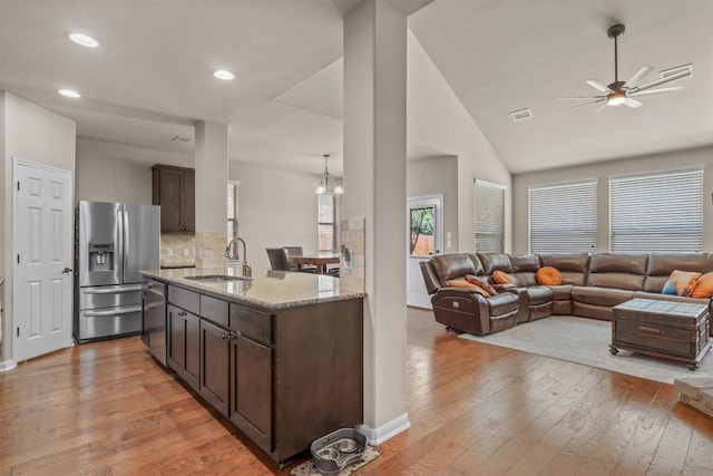 204 Archipelago Trl, Austin, TX 78717 - kitchen with appliances with stainless steel finishes, open floor plan, dark brown cabinetry, a ceiling fan, and light wood finished floors