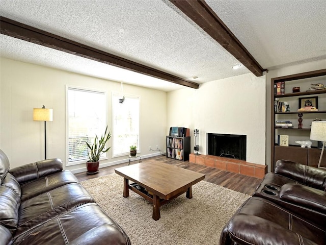100 Lido Cir Unit A1, Lakeway, TX 78734 - living room with a textured ceiling, beam ceiling, wood finished floors, and a fireplace