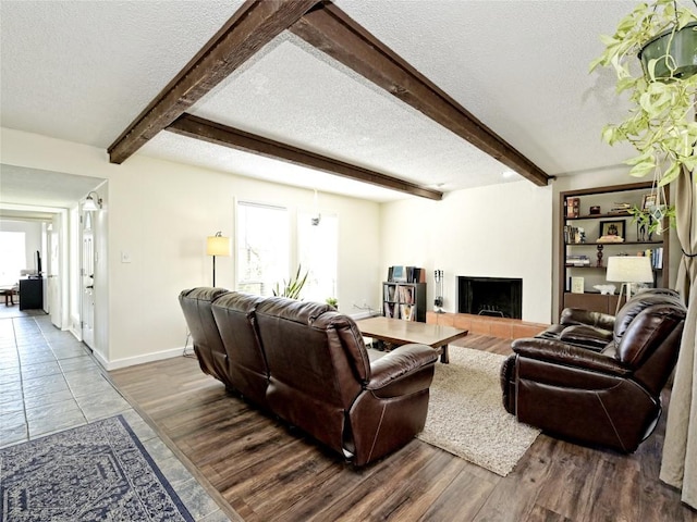 100 Lido Cir Unit A1, Lakeway, TX 78734 - living area featuring a textured ceiling, healthy amount of natural light, a fireplace with raised hearth, and beam ceiling