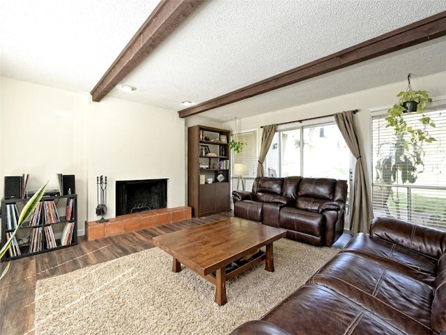 100 Lido Cir Unit A1, Lakeway, TX 78734 - living area with beamed ceiling, wood finished floors, a tile fireplace, and a textured ceiling