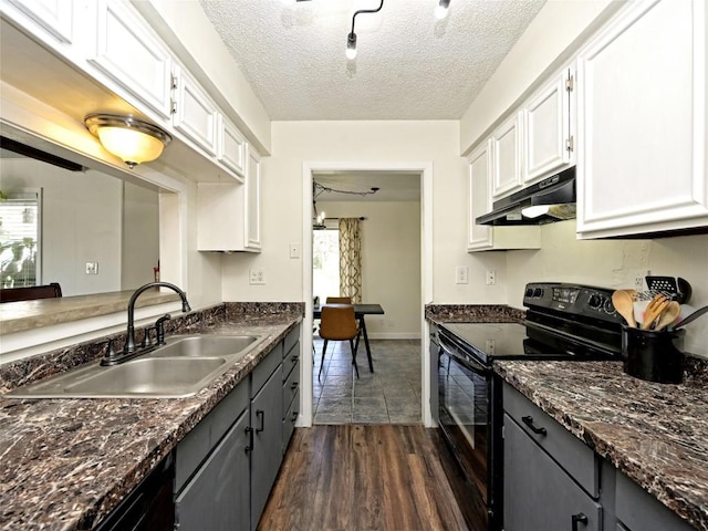 100 Lido Cir Unit A1, Lakeway, TX 78734 - kitchen with black range with electric stovetop, under cabinet range hood, white cabinets, dark wood finished floors, and a textured ceiling