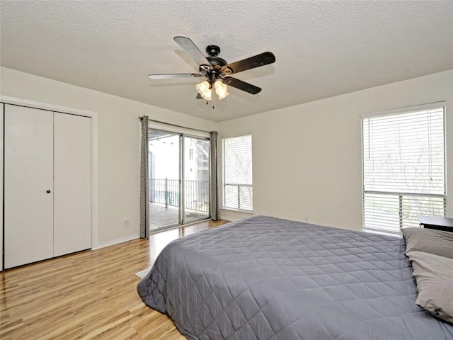 100 Lido Cir Unit A1, Lakeway, TX 78734 - bedroom featuring access to outside, light wood finished floors, a textured ceiling, and ceiling fan