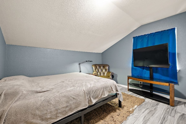 3010 Adam Cv, Round Rock, TX 78681 - bedroom featuring vaulted ceiling, wood finished floors, a textured ceiling, and a textured wall