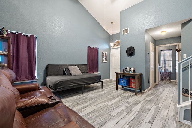 3010 Adam Cv, Round Rock, TX 78681 - living area featuring high vaulted ceiling, light wood-style flooring, and a textured wall
