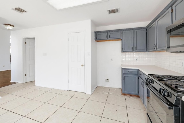 1505 Thibodeaux Dr, Round Rock, TX 78664 - kitchen featuring stainless steel microwave, black gas range, tasteful backsplash, light countertops, and light tile patterned floors