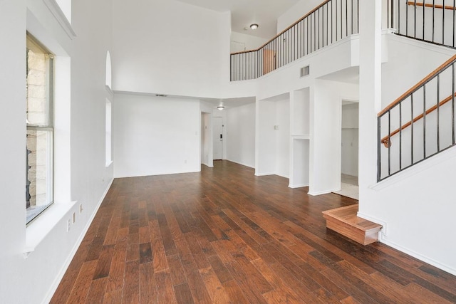 1505 Thibodeaux Dr, Round Rock, TX 78664 - unfurnished living room featuring a high ceiling, stairs, and wood finished floors