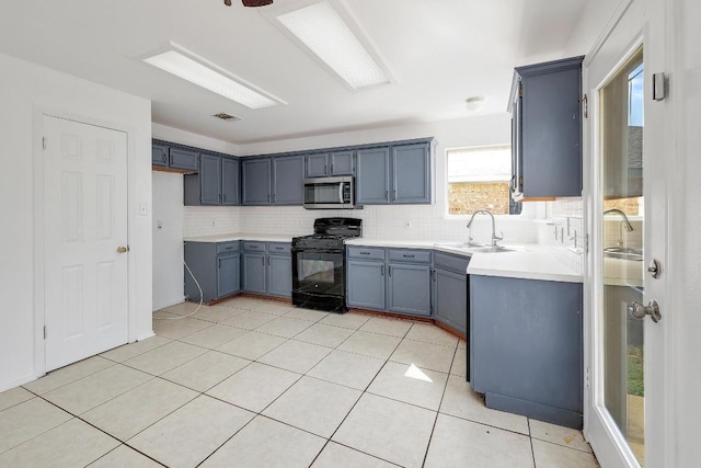 1505 Thibodeaux Dr, Round Rock, TX 78664 - kitchen featuring black range with gas stovetop, stainless steel microwave, decorative backsplash, light countertops, and light tile patterned flooring