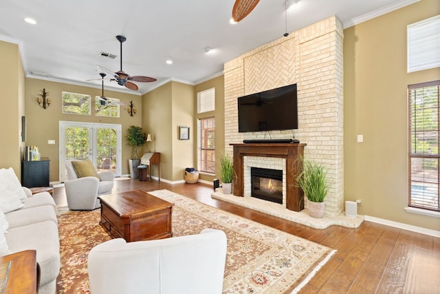 1005 Terry Ln, Kingsland, TX 78639 - living area featuring a ceiling fan, crown molding, wood-type flooring, plenty of natural light, and a fireplace