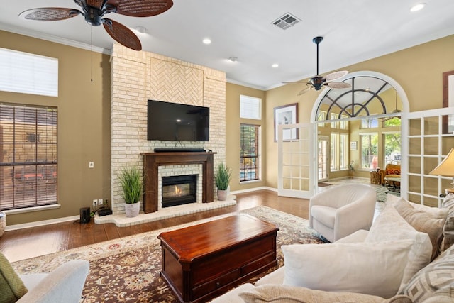 1005 Terry Ln, Kingsland, TX 78639 - living room with a ceiling fan, wood finished floors, ornamental molding, a fireplace, and recessed lighting