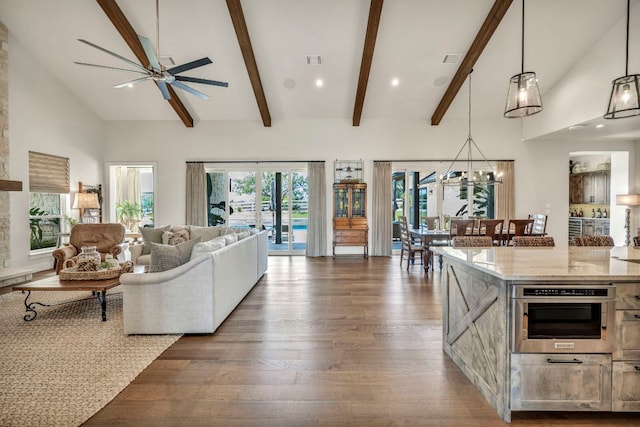 196 Westgate Loop, Horseshoe Bay, TX 78657 - living area featuring dark wood finished floors, a ceiling fan, plenty of natural light, beamed ceiling, and a chandelier