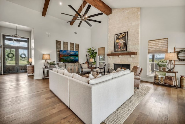 196 Westgate Loop, Horseshoe Bay, TX 78657 - living room with high vaulted ceiling, a stone fireplace, ceiling fan, beamed ceiling, and wood finished floors