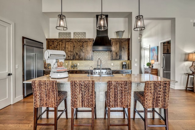 196 Westgate Loop, Horseshoe Bay, TX 78657 - kitchen featuring built in fridge, freestanding refrigerator, decorative backsplash, and a kitchen breakfast bar