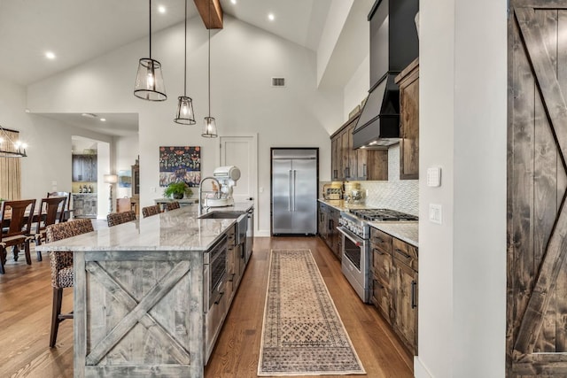 196 Westgate Loop, Horseshoe Bay, TX 78657 - kitchen featuring high end appliances, a breakfast bar, dark wood-style flooring, high vaulted ceiling, and a large island with sink
