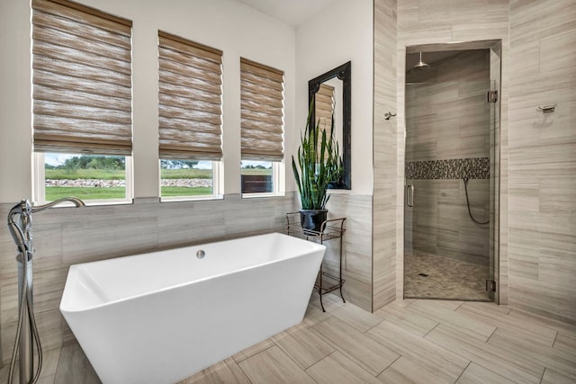 196 Westgate Loop, Horseshoe Bay, TX 78657 - full bath with tile walls, a shower stall, and a freestanding tub