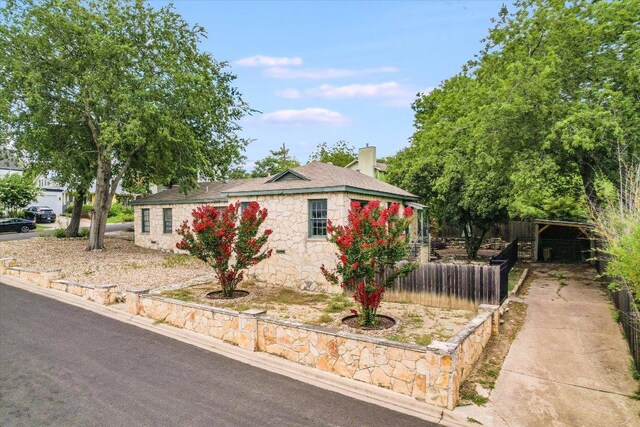 1410 Burford Pl, Austin, TX 78704 - ranch-style house with stone siding, concrete driveway, and a chimney