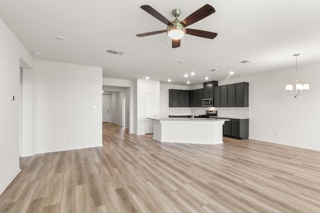 3715 Liberi Ln, Round Rock, TX 78665 - unfurnished living room with recessed lighting, a chandelier, light wood finished floors, and ceiling fan