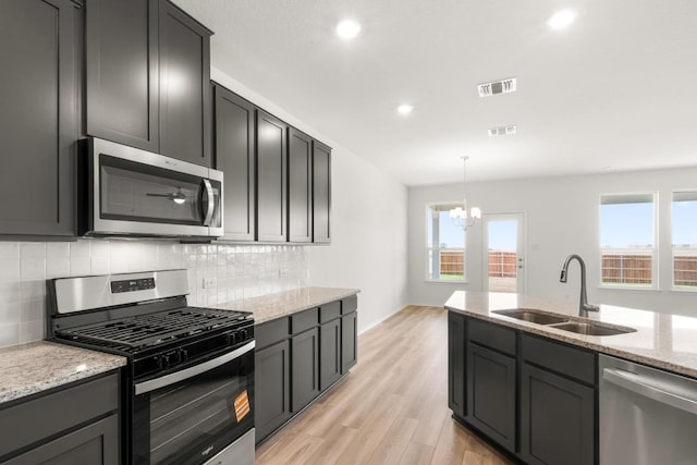3715 Liberi Ln, Round Rock, TX 78665 - kitchen featuring stainless steel appliances, backsplash, healthy amount of natural light, a chandelier, and recessed lighting