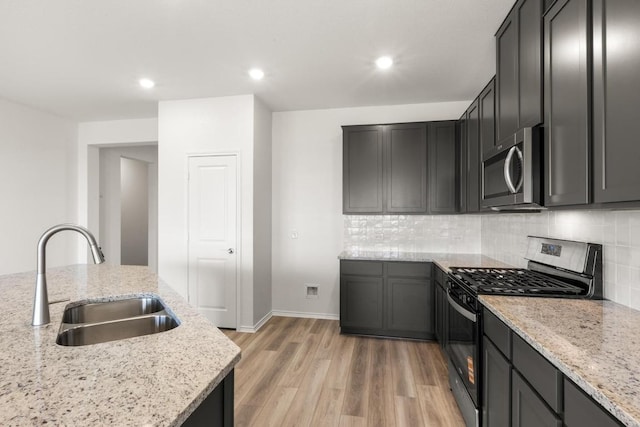 3715 Liberi Ln, Round Rock, TX 78665 - kitchen with appliances with stainless steel finishes, light wood-style flooring, tasteful backsplash, light stone counters, and recessed lighting