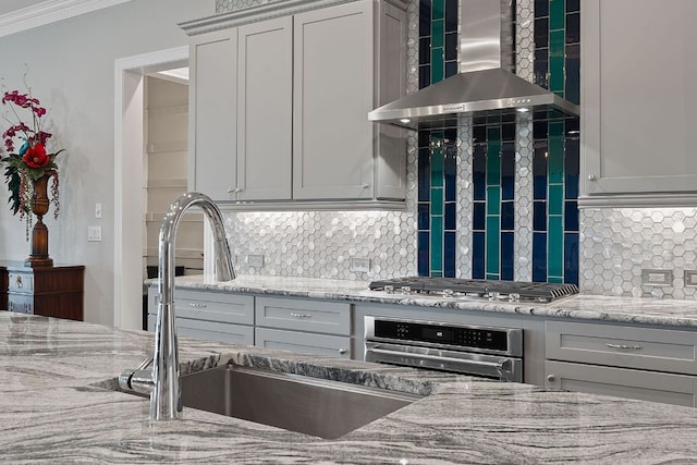 306 Iron Rail Ln, Georgetown, TX 78633 - kitchen featuring wall chimney range hood, stainless steel appliances, backsplash, light stone counters, and crown molding