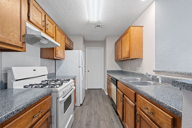 12323 Alderbrook Dr, Austin, TX 78758 - kitchen with white gas range, under cabinet range hood, light wood-style floors, dishwashing machine, and dark countertops