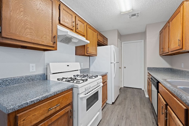 12323 Alderbrook Dr, Austin, TX 78758 - kitchen featuring white gas range oven, under cabinet range hood, light wood finished floors, brown cabinets, and a textured ceiling