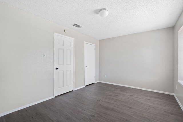 12323 Alderbrook Dr, Austin, TX 78758 - unfurnished bedroom featuring dark wood-type flooring and a textured ceiling