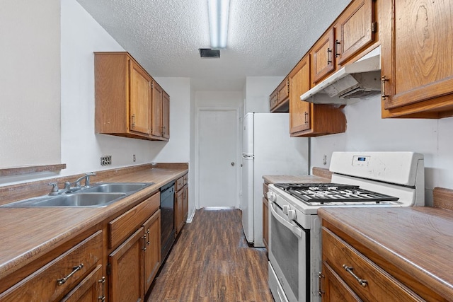 12323 Alderbrook Dr, Austin, TX 78758 - kitchen featuring white gas range, under cabinet range hood, brown cabinets, dark wood finished floors, and a textured ceiling