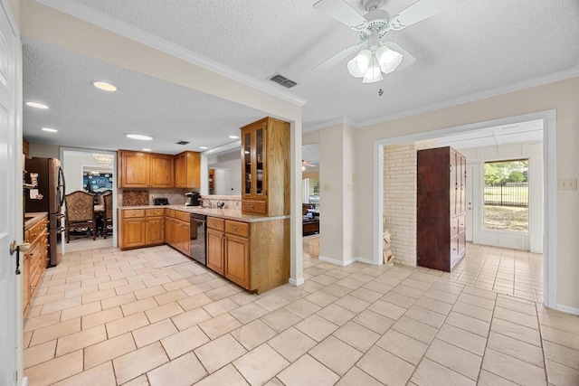 9202 Spring Hollow Dr, Austin, TX 78750 - kitchen featuring a textured ceiling, freestanding refrigerator, brown cabinetry, light countertops, and dishwashing machine