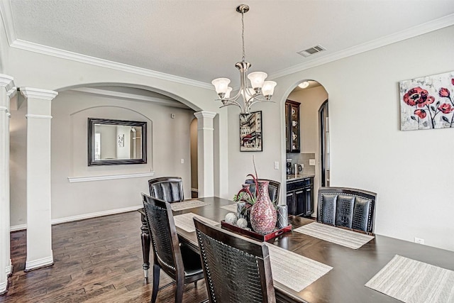 536 Middle Brook Dr, Leander, TX 78641 - dining room with ornate columns, arched walkways, dark wood finished floors, crown molding, and a chandelier