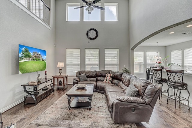 536 Middle Brook Dr, Leander, TX 78641 - living room with arched walkways, a ceiling fan, wood finished floors, healthy amount of natural light, and a towering ceiling