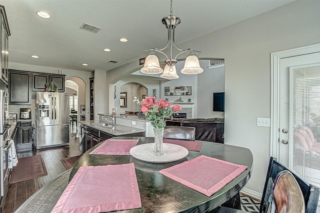 536 Middle Brook Dr, Leander, TX 78641 - dining area with arched walkways, recessed lighting, dark wood finished floors, and a fireplace
