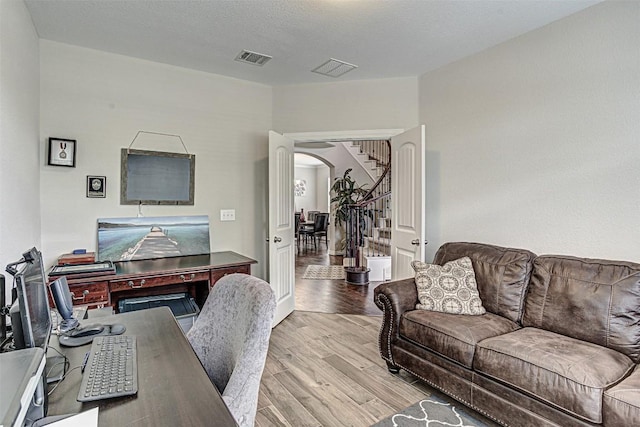 536 Middle Brook Dr, Leander, TX 78641 - living room with arched walkways, wood finished floors, and stairway