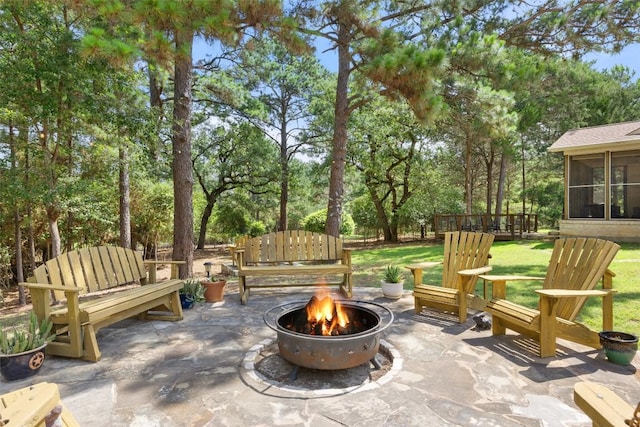 236 Pony Express Dr, Smithville, TX 78957 - view of patio / terrace featuring an outdoor fire pit, a sunroom, and view of scattered trees