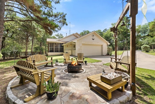 236 Pony Express Dr, Smithville, TX 78957 - view of patio / terrace with an outdoor fire pit, a sunroom, an attached garage, and concrete driveway