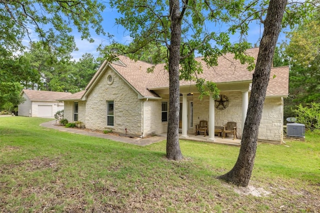 236 Pony Express Dr, Smithville, TX 78957 - ranch-style home featuring stone siding, a shingled roof, a front yard, and a patio area