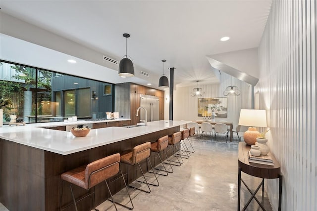 1327 Bonham Ter Unit B, Austin, TX 78704 - kitchen featuring finished concrete flooring, light countertops, a kitchen breakfast bar, and modern cabinets