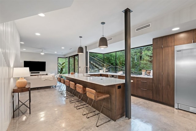 1327 Bonham Ter Unit B, Austin, TX 78704 - kitchen featuring stainless steel built in fridge, finished concrete flooring, healthy amount of natural light, a kitchen bar, and recessed lighting