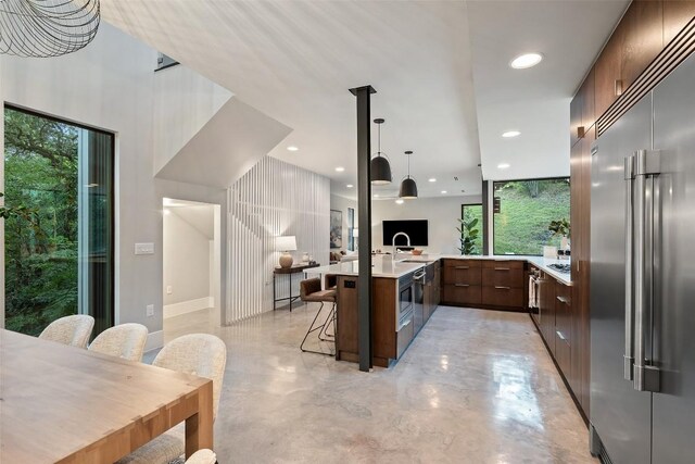 1327 Bonham Ter Unit B, Austin, TX 78704 - kitchen featuring built in refrigerator, modern cabinets, light countertops, a breakfast bar, and healthy amount of natural light