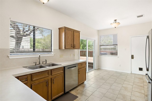 5910 Abilene Trl, Austin, TX 78749 - kitchen with stainless steel appliances, light countertops, brown cabinets, and light tile patterned flooring