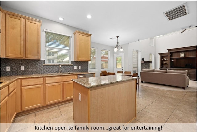 8300 Fern Bluff Ave, Round Rock, TX 78681 - kitchen featuring a kitchen island, light tile patterned flooring, decorative backsplash, light stone counters, and light brown cabinetry