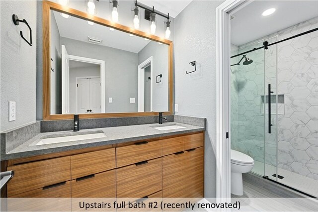 8300 Fern Bluff Ave, Round Rock, TX 78681 - bathroom featuring a shower stall, double vanity, and a textured wall