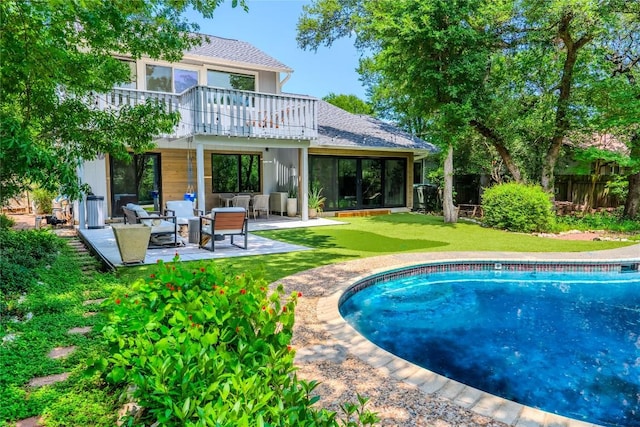 4407 Ganymede Dr, Austin, TX 78727 - rear view of house featuring an outdoor living space, a patio area, an outdoor pool, roof with shingles, and a balcony
