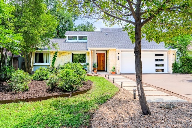 4407 Ganymede Dr, Austin, TX 78727 - mid-century home with stone siding, driveway, an attached garage, and roof with shingles