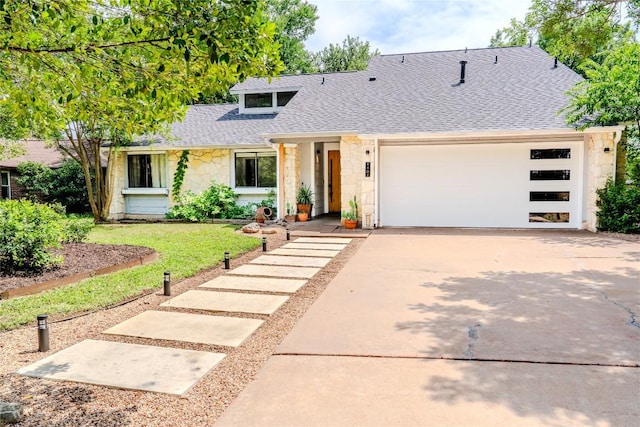 4407 Ganymede Dr, Austin, TX 78727 - view of front of house featuring stone siding, a shingled roof, driveway, an attached garage, and a front lawn
