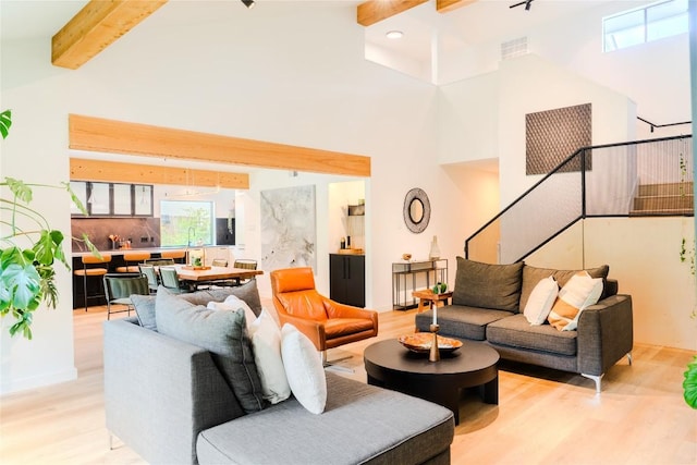 4407 Ganymede Dr, Austin, TX 78727 - living room featuring light wood-style floors, beam ceiling, stairway, and a towering ceiling