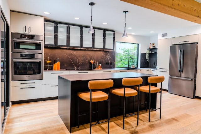 4407 Ganymede Dr, Austin, TX 78727 - kitchen featuring appliances with stainless steel finishes, modern cabinets, light wood finished floors, and recessed lighting